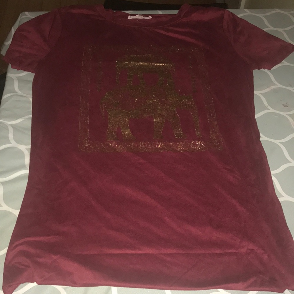 A burgundy shirt with a golden elephant design